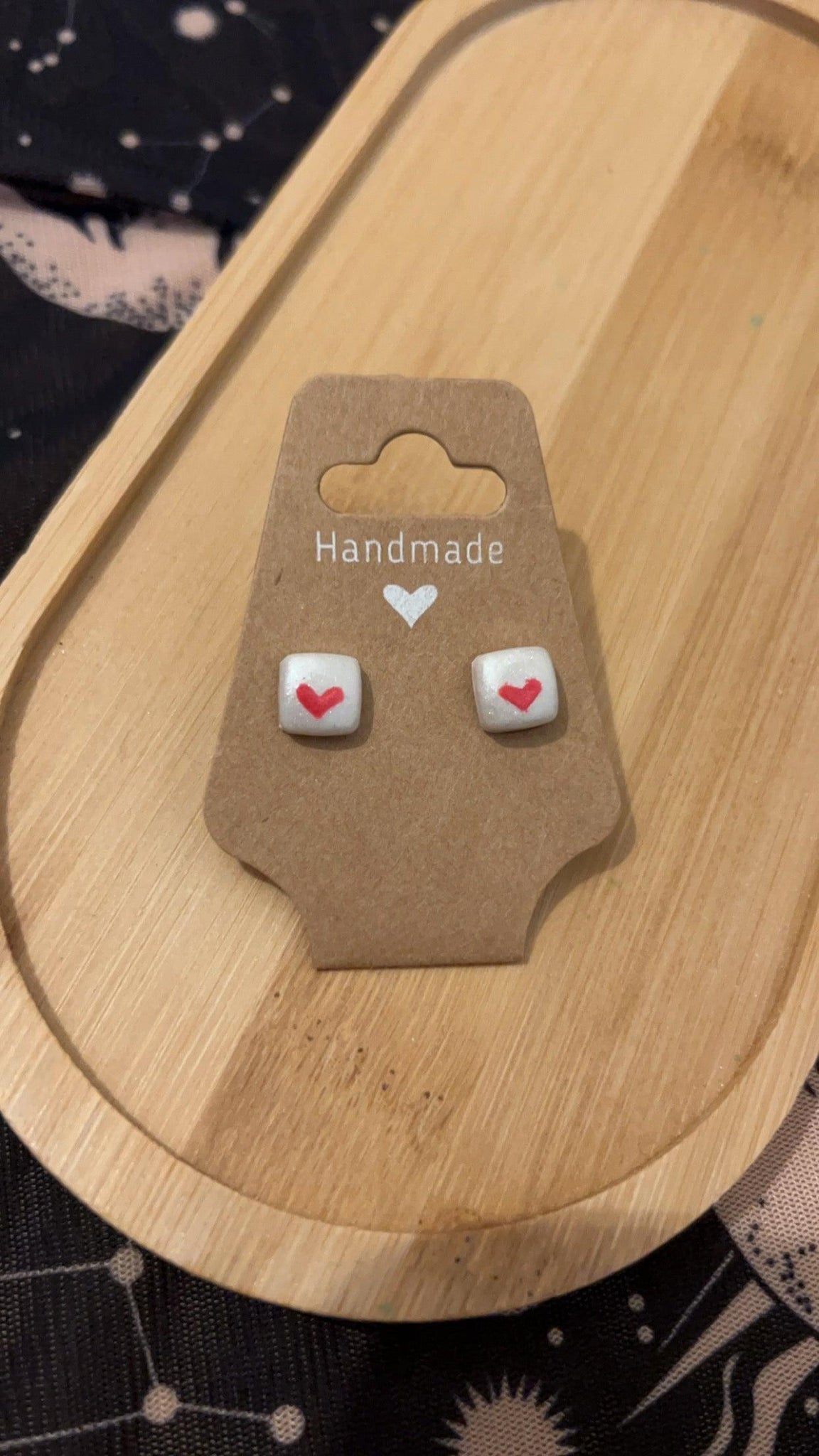 First love has white background with red love heart stud earrings. 