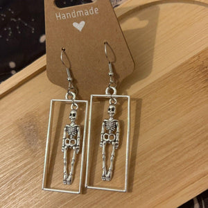 Gothic Skeleton in silver rectangle frame Earrings from a side angle 